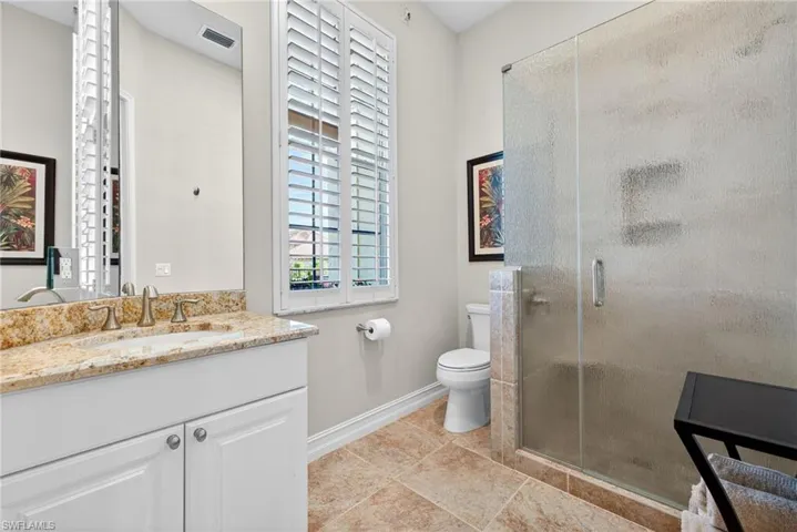 Full bathroom featuring vanity, a stall shower, and light tile patterned floors