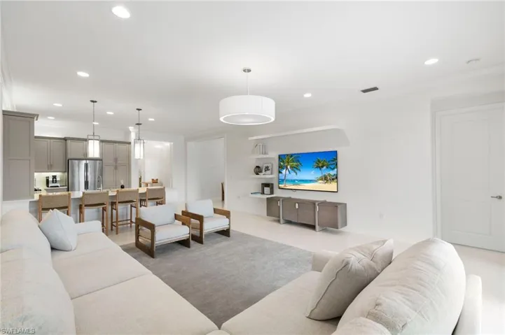Living room featuring recessed lighting, crown molding, and a chandelier