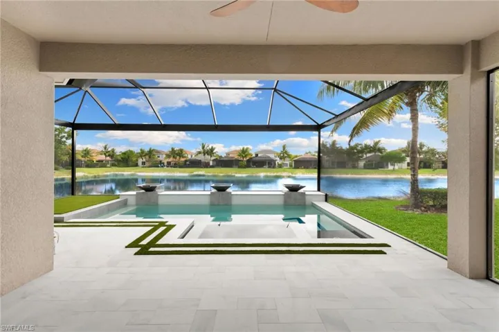 View of swimming pool with a sunroom, a patio area, and glass enclosure