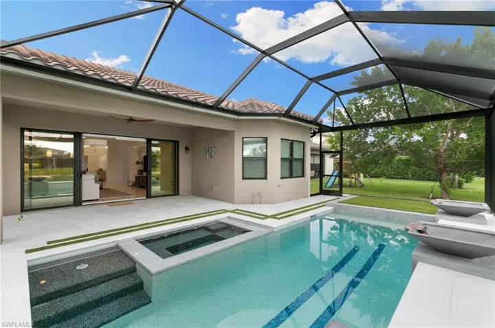 View of swimming pool featuring a sunroom, glass enclosure, and a ceiling fan