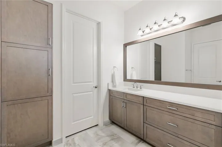 Bathroom with vanity and light marble finish floors