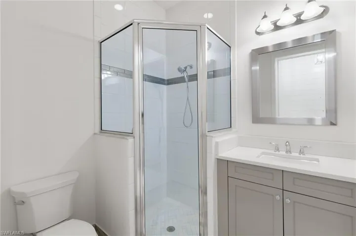 Full bath featuring vanity and a shower stall