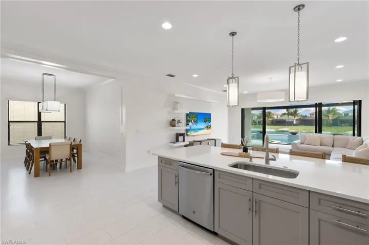 Kitchen featuring stainless steel appliances, backsplash, and light stone counters