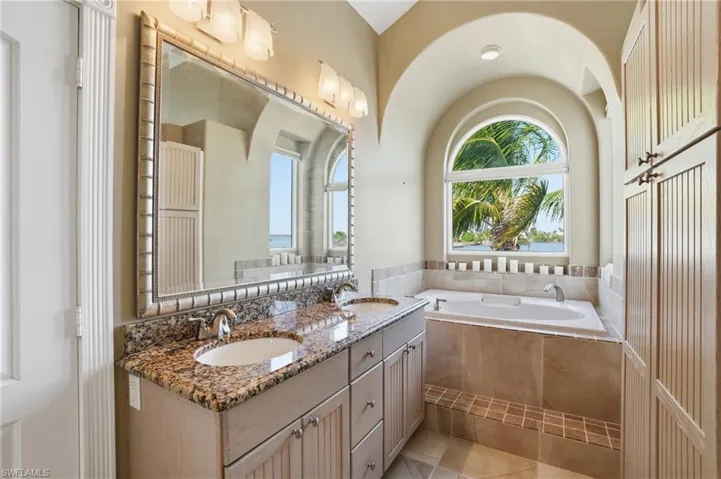 Full bathroom with double vanity, a garden tub, and healthy amount of natural light - Virtually Edited Image