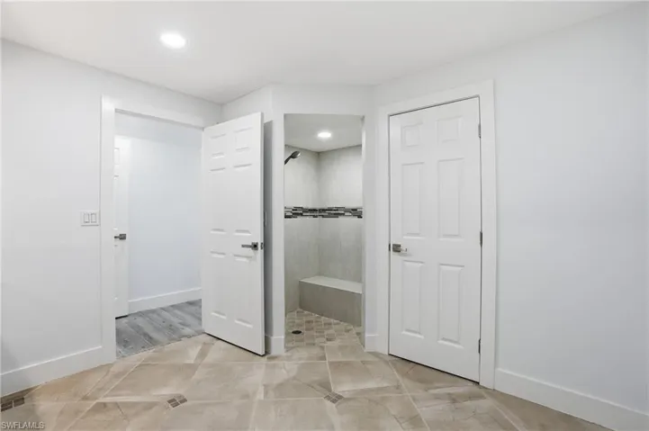 Full bath featuring tiled shower, recessed lighting, and light tile patterned flooring - Virtually Edited Image
