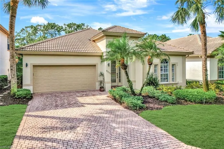 Mediterranean / spanish house featuring a garage, a tile roof, decorative driveway, and stucco siding