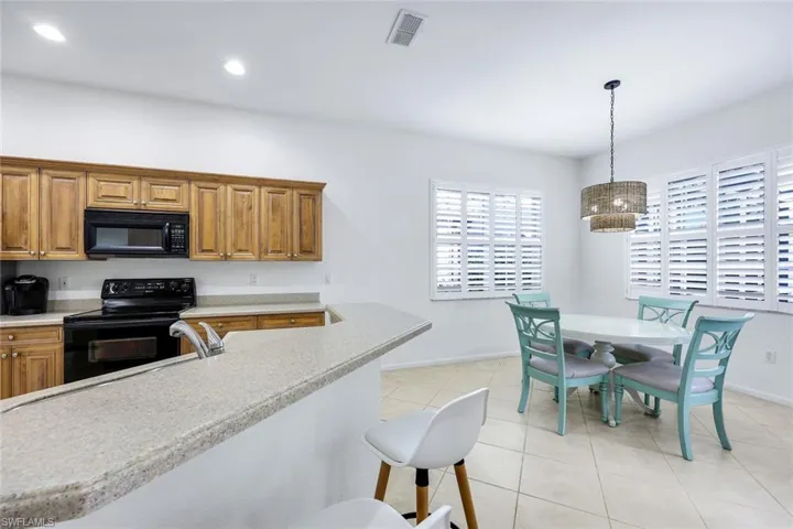 Kitchen featuring visible vents, light countertops, black appliances, a sink, and light tile patterned flooring