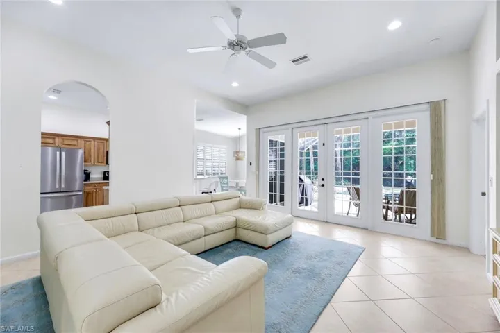 Living room with recessed lighting, light tile patterned flooring, and visible vents
