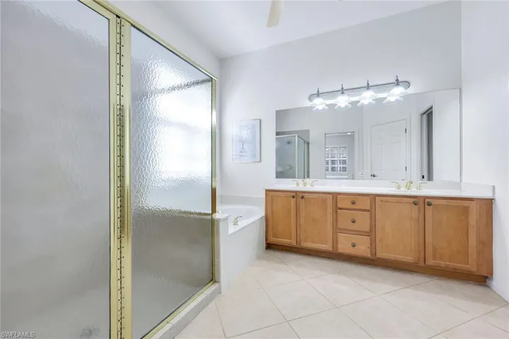 Full bath with a garden tub, tile patterned flooring, a sink, and a shower stall