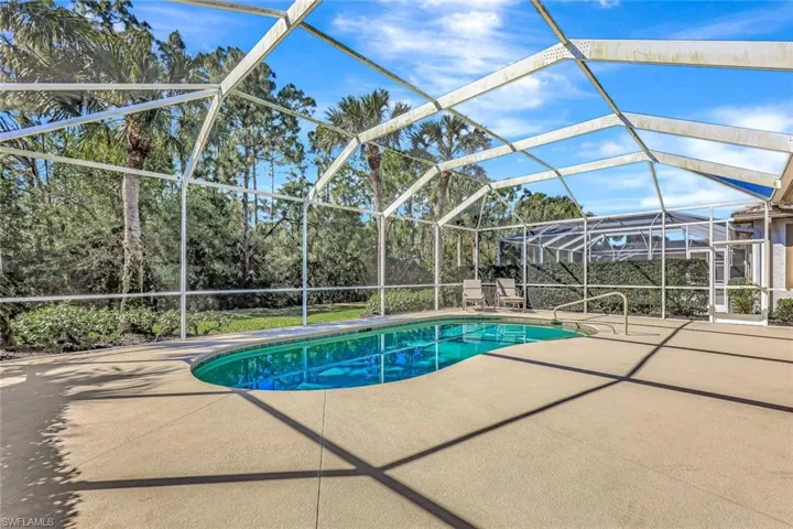 Pool with a patio and glass enclosure