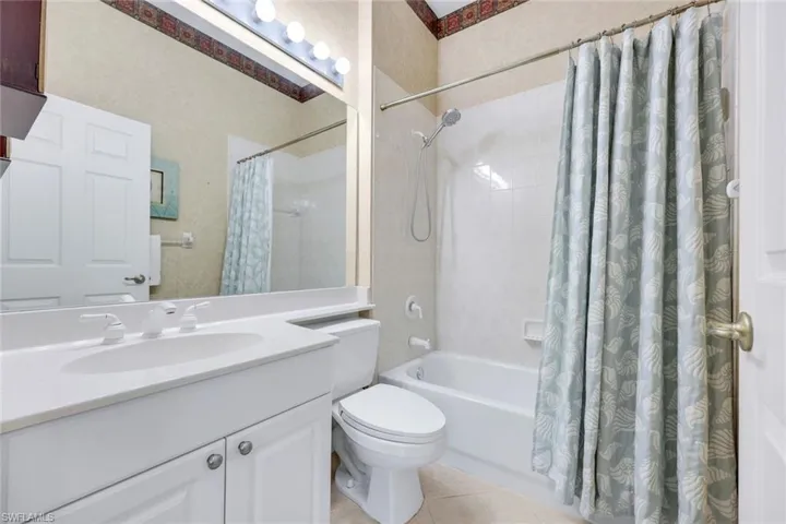 Bathroom with toilet, shower / bath combo, and vanity