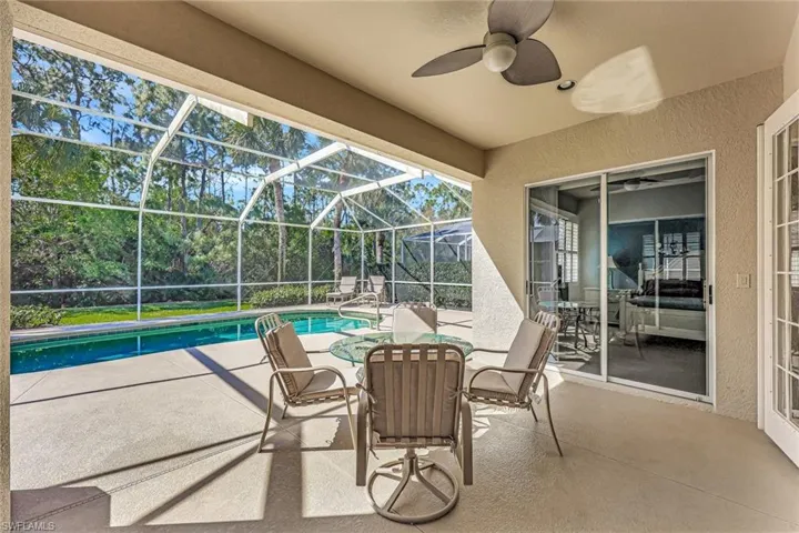 View of patio / terrace featuring a lanai, a ceiling fan, and an outdoor pool
