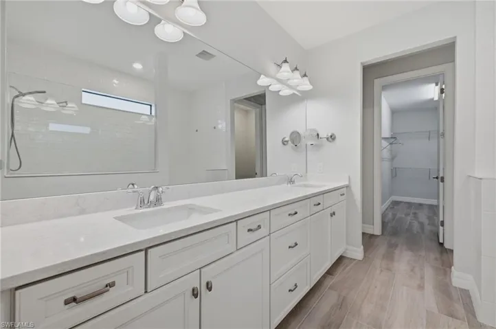 Double vanity with undermount sinks, chrome fixtures, and a spacious mirror