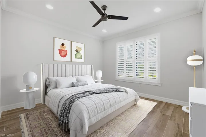 Spacious room featuring wood-finish flooring, crown molding, a ceiling fan, recessed lighting, and a large window with plantation shutters