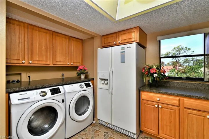Laundry area with cabinets, a textured ceiling, and washing machine and dryer