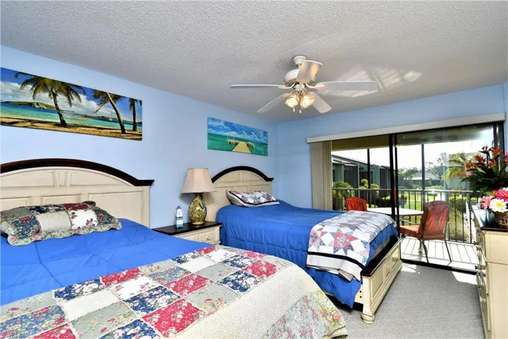 Bedroom with ceiling fan, carpet floors, a textured ceiling, and access to outside