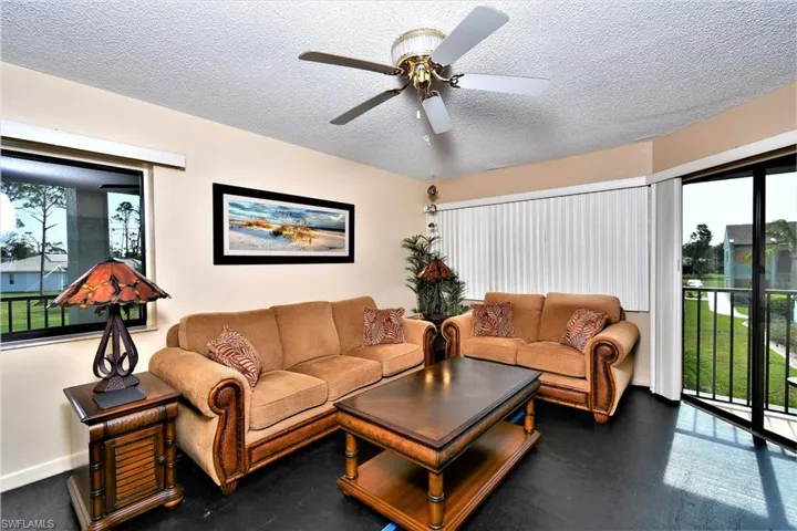 Living room featuring ceiling fan and a textured ceiling