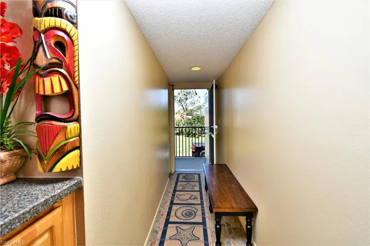Hall with a textured ceiling and tile patterned flooring
