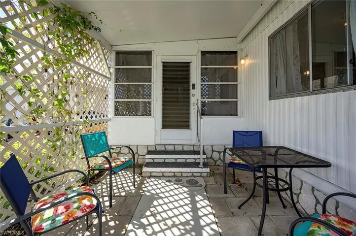 View of patio with outdoor dining space and entry steps