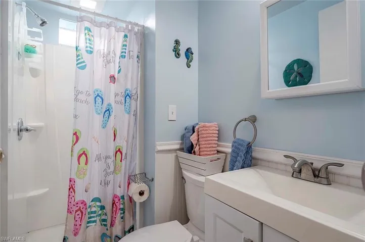 Bathroom featuring vanity, toilet, and curtained shower