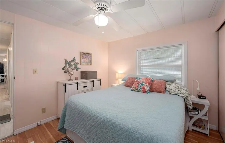 Bedroom with baseboards, light wood finished floors, and ceiling fan