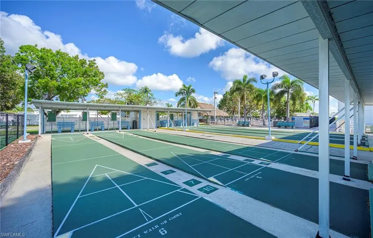 Surrounding community featuring shuffleboard and fence