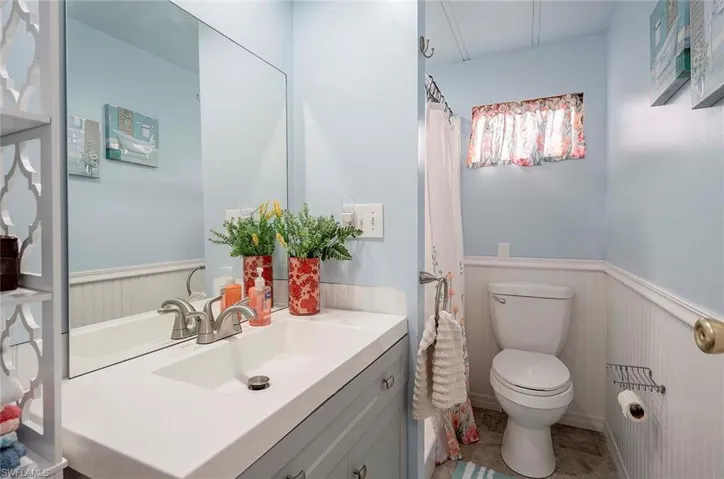 Bathroom with vanity, toilet, and wainscoting