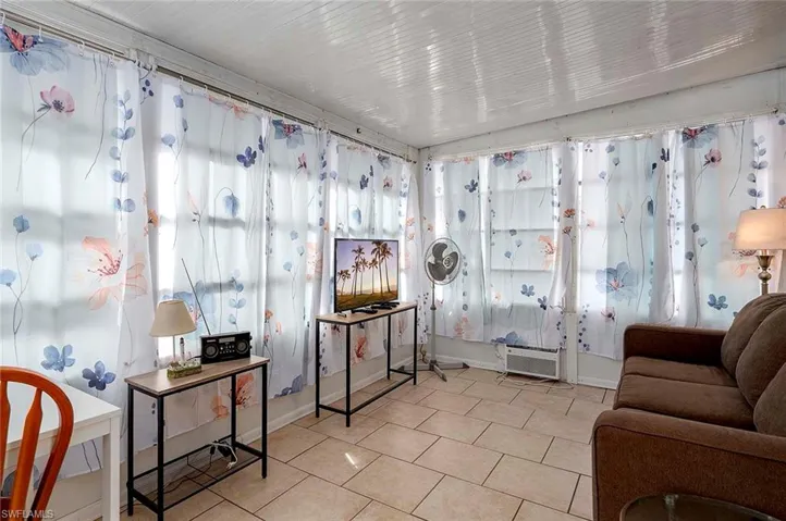 Living area featuring baseboards and tile patterned flooring