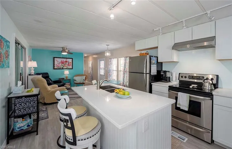 Kitchen featuring light wood finished floors, appliances with stainless steel finishes, open floor plan, under cabinet range hood, and visible vents