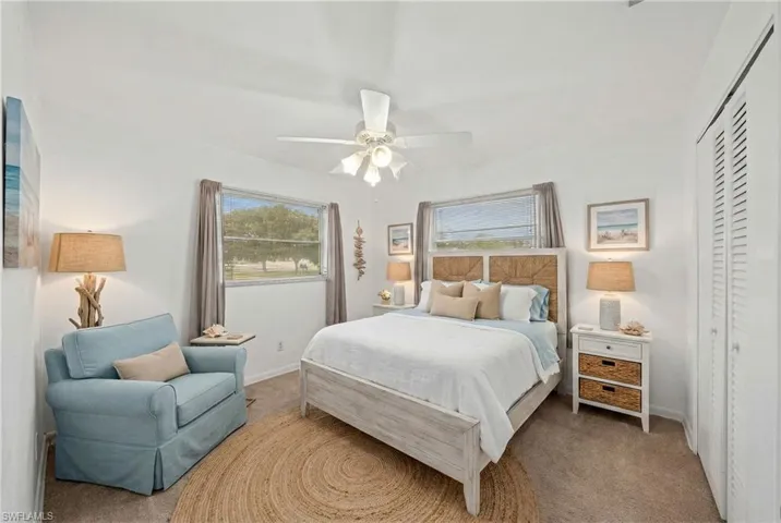 Bedroom with multiple windows, carpet flooring, a ceiling fan, and a closet