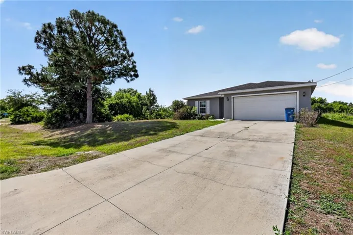 Single-story residence featuring a gray exterior, a two-car garage, and a concrete driveway