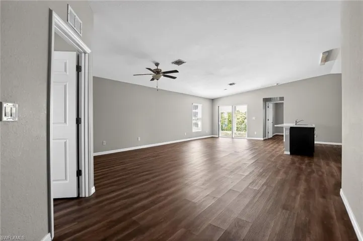 Spacious interior with wood-finish flooring, vaulted ceilings, and light gray wall paint