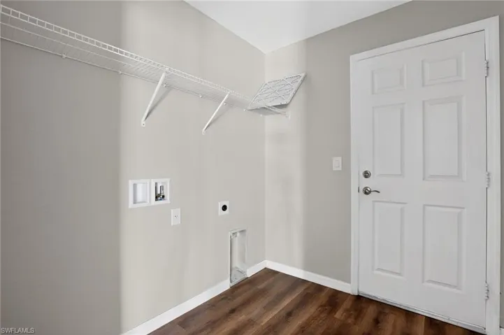 Utility area featuring a paneled door, wire shelving, wood-finish flooring, and light gray wall paint
