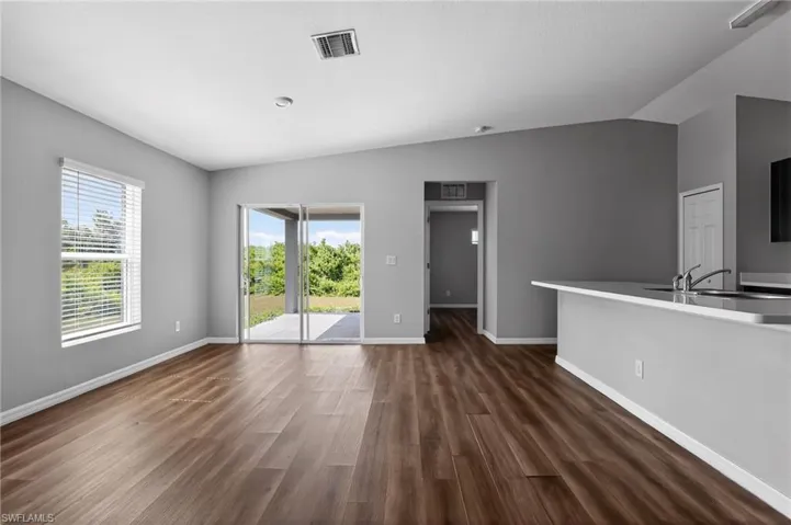 Spacious living area featuring wood-finish flooring and light gray wall tones