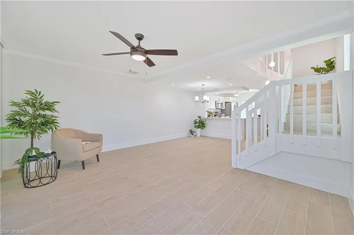 Unfurnished room with ornamental molding, light hardwood / wood-style flooring, and ceiling fan with notable chandelier