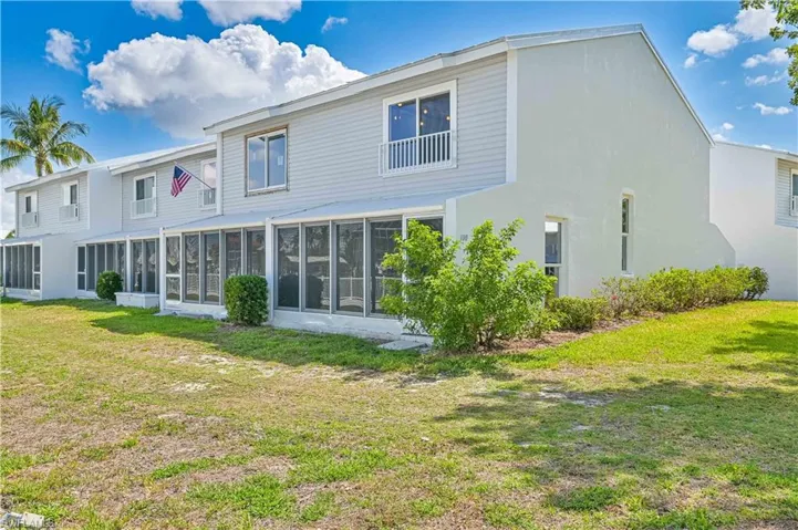 Back of property with a sunroom and a yard