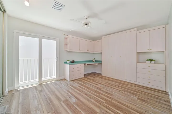 Kitchen featuring built in desk, ceiling fan, and light hardwood / wood-style floors