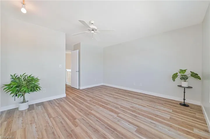 Empty room with ceiling fan and light hardwood / wood-style flooring
