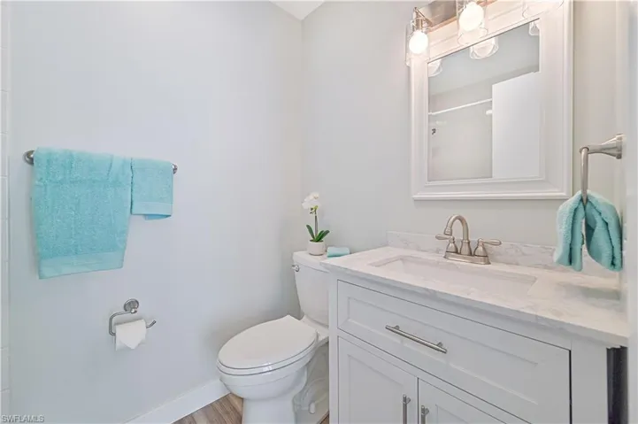 Bathroom featuring hardwood / wood-style flooring, oversized vanity, and toilet