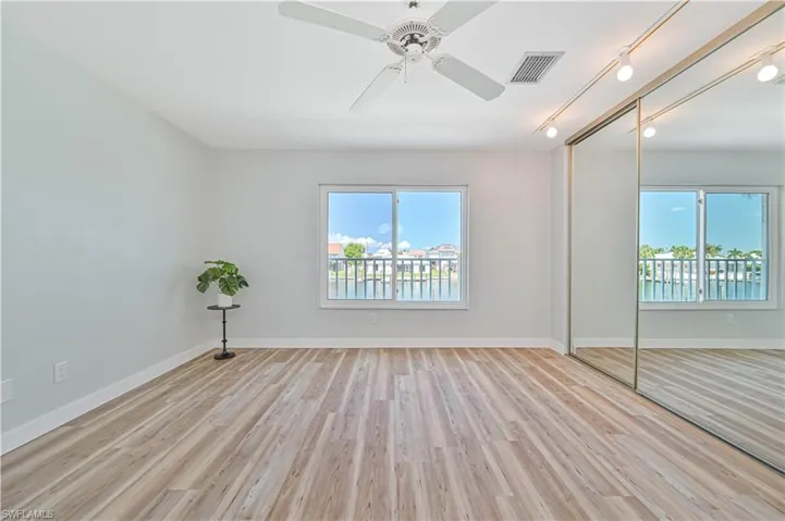 Unfurnished bedroom with a closet, multiple windows, and light hardwood / wood-style flooring