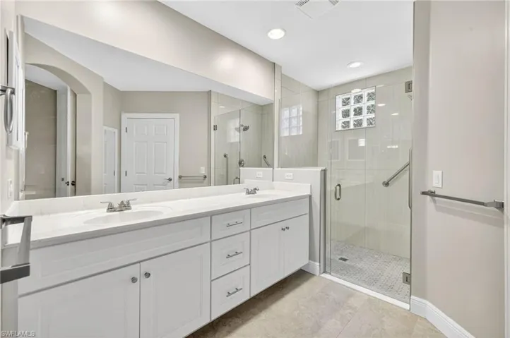 Updated primary bath with dual sinks and seamless shower door.