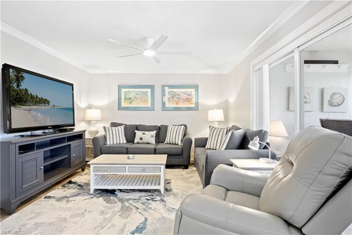 Living room featuring a ceiling fan and ornamental molding