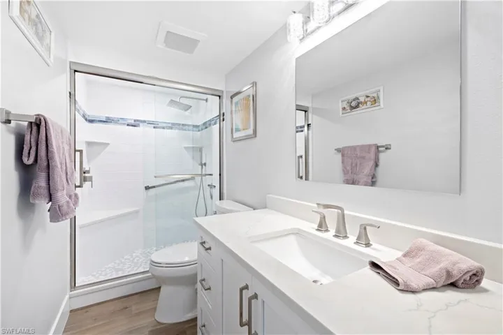 Bathroom featuring vanity, a shower stall, and wood finished floors