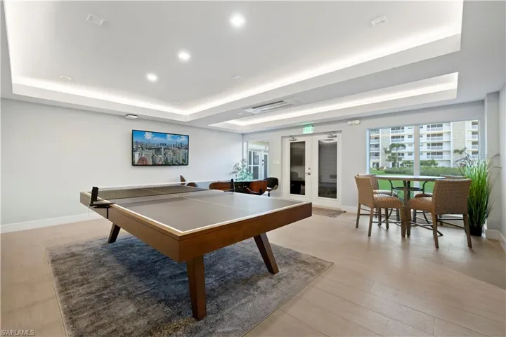 Playroom featuring a tray ceiling, french doors, recessed lighting, and light wood-style floors