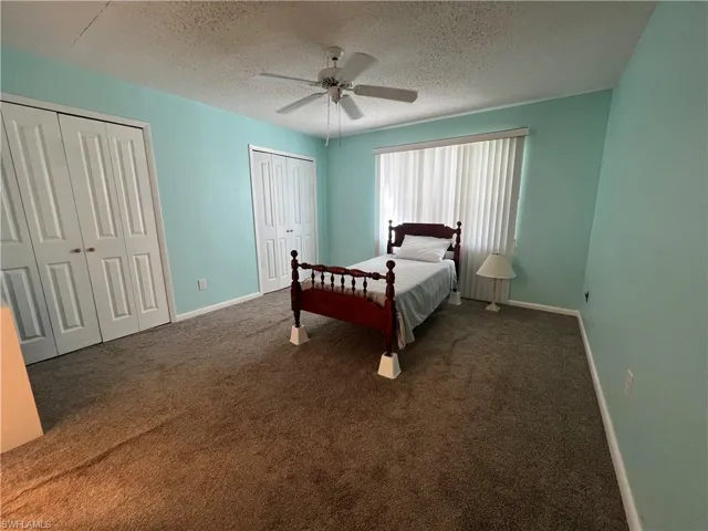 Primary Bedroom featuring carpet, two closets & ceiling fan