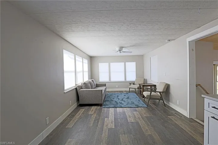 Sitting room featuring dark wood-style flooring and ceiling fan