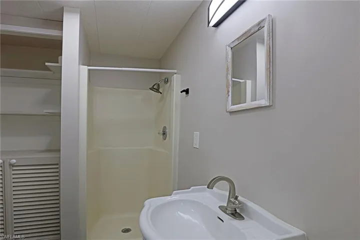 Bathroom featuring a shower stall and a sink