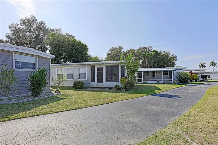 Manufactured / mobile home with a front yard and a sunroom