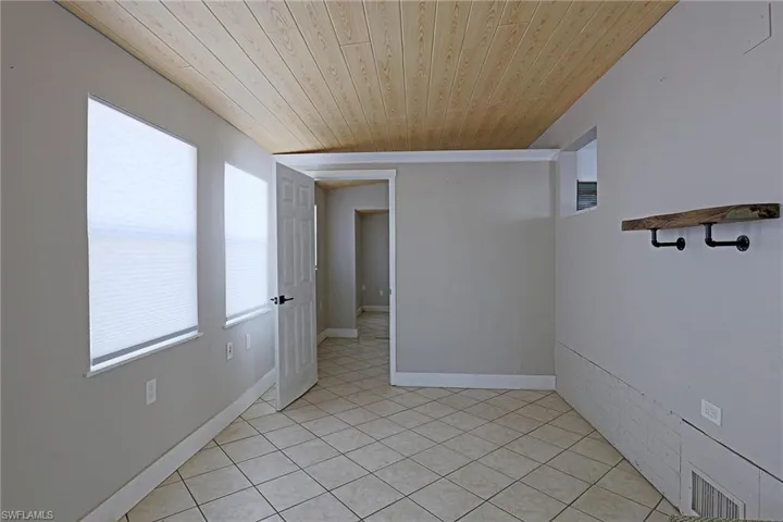 Empty room featuring wood ceiling and light tile patterned flooring