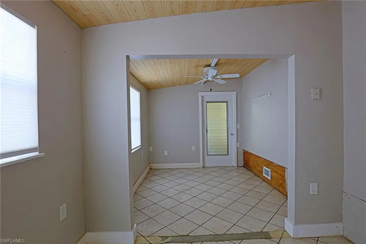 Spare room featuring wood ceiling, light tile patterned flooring, a ceiling fan, and lofted ceiling